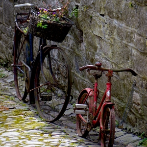 Deux vélos posés sur un mur de pierres dans une rue pavée - Belgique  - collection de photos clin d'oeil, catégorie rues